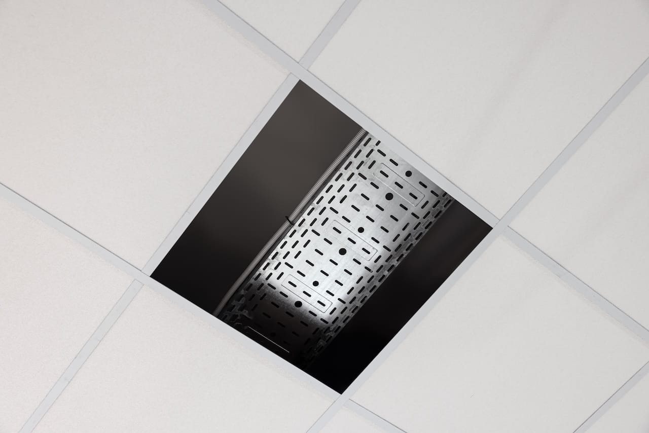 View from below on PVC tiles. Installing ceiling lighting